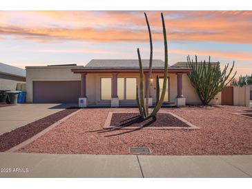 Charming single-story home featuring desert landscaping, a two-car garage, and neutral exterior paint at 4231 W Villa Maria Dr, Glendale, AZ 85308