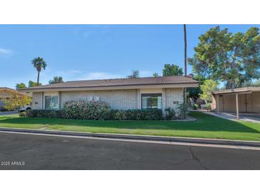 Charming single-story home with well-maintained landscaping and a tile roof under a beautiful blue sky at 4525 N 66Th St # 10, Scottsdale, AZ 85251