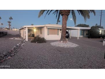 Single-story home boasting a covered parking, complemented by rock landscaping, and palm trees at 103 S 75Th Pl, Mesa, AZ 85208