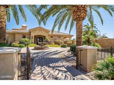 Stunning front exterior featuring a circular driveway, lush greenery, and water fountain at 1367 S Country Club Dr # 1127, Mesa, AZ 85210