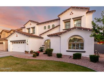 Charming two-story home featuring a well-maintained lawn, arched entryway, and a three-car garage at 1429 E Lowell Ave, Gilbert, AZ 85295