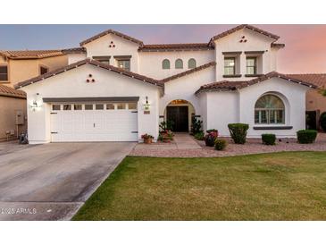 Charming two-story home featuring a well-maintained lawn, arched entryway, and a three-car garage at 1429 E Lowell Ave, Gilbert, AZ 85295