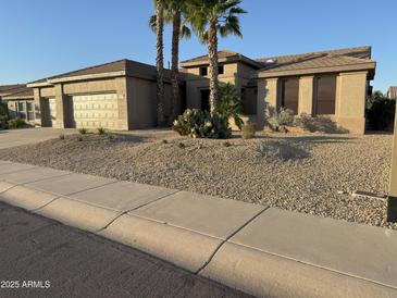Charming single-story home with a low maintenance desert landscape and a three car garage at 15801 W Goldenrod Dr, Surprise, AZ 85374