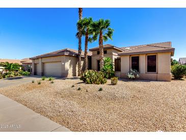Beautiful single story home with desert landscaping and mature palm trees enhancing the curb appeal at 15801 W Goldenrod Dr, Surprise, AZ 85374