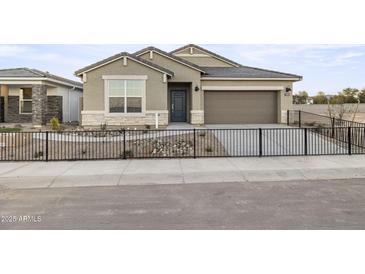 Charming single-story home featuring a two-car garage and low maintenance desert landscaping at 17731 W Onyx Ave, Waddell, AZ 85355
