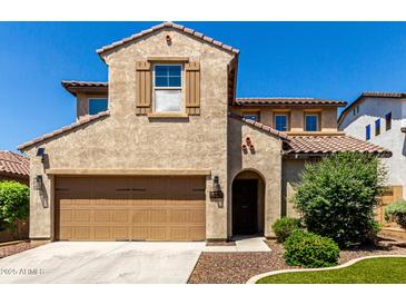 Charming two-story home with a well-manicured lawn, a brown door, and a two-car garage at 1806 W Fetlock Trl, Phoenix, AZ 85085