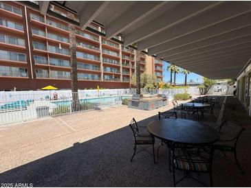 Outdoor patio with BBQ grills near a sparkling pool with lounge chairs and lush landscaping at 4750 N Central Ave # R3, Phoenix, AZ 85012