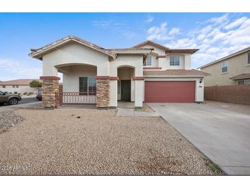 Charming two-story home with a red two-car garage, stone accents, and a covered front porch at 7309 W Getty Dr, Phoenix, AZ 85043