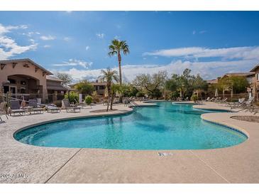 Enjoy resort-style living with this community pool, surrounded by palm trees and lounge chairs at 11500 E Cochise Dr # 2088, Scottsdale, AZ 85259