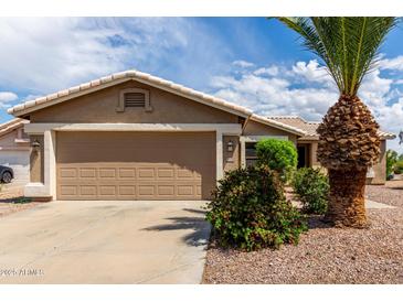 Charming single-story home with a two-car garage, desert landscaping, and a well-maintained front yard at 11520 W Lizard Ct, Surprise, AZ 85378