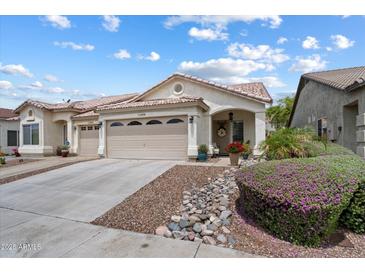 Inviting single-story home with desert landscaping, covered porch, and three-car garage at 16636 S 22Nd St, Phoenix, AZ 85048