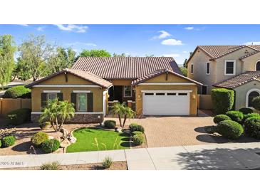 Charming single-Gathering home showcasing a well-manicured lawn, beautiful shrubbery, and a two-car garage at 19291 E Thornton Rd, Queen Creek, AZ 85142