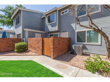 Charming two-story home with a brick wall, wooden gate and freshly manicured lawn at 2301 E University Dr # 233, Mesa, AZ 85213