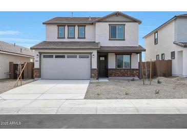 Two-story home featuring a two car garage, neutral paint, and low maintenance desert landscaping at 24249 W Agora Ln, Buckeye, AZ 85326