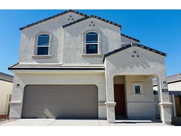 Charming two-story home featuring a stucco exterior, a gray tile roof, and an attached two-car garage at 5058 E Umber Rd, San Tan Valley, AZ 85143