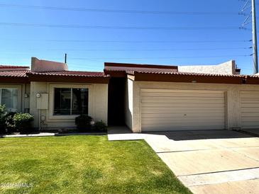 Charming single-story home with a well-manicured lawn, garage and desert landscaping at 6845 W Caron Dr, Peoria, AZ 85345