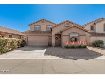 Charming two-story home featuring a well-manicured lawn and a two-car garage under a clear blue sky at 8802 E University Dr # 28, Mesa, AZ 85207