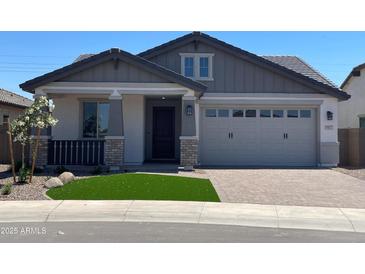 Charming single-story home featuring a two-car garage and well-manicured front yard with synthetic grass at 9963 W Verde Ln, Avondale, AZ 85392