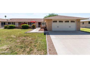 Charming single-story home featuring a two-car garage, well-maintained landscaping, and inviting curb appeal at 15614 N Lakeforest Dr, Sun City, AZ 85351