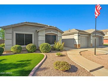 Inviting single-story home with well-manicured lawn and a charming walkway to the garage at 16396 W Fillmore St, Goodyear, AZ 85338