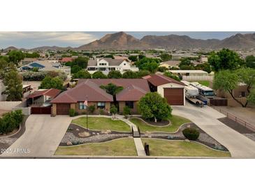 Expansive single-story home featuring mature trees, lush landscaping and mountain views at 21131 E Excelsior Ave, Queen Creek, AZ 85142