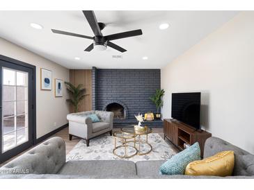 Inviting living room with a gray sofa, arm chair, decorative fireplace, and plenty of natural light at 2313 N 66Th St, Scottsdale, AZ 85257