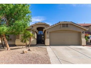 Inviting home with a two-car garage, desert landscaping, and a charming entrance at 42277 W Chisholm Dr, Maricopa, AZ 85138