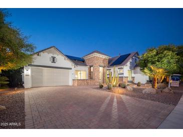 Beautiful single-Gathering home showcasing a brick driveway, desert landscaping, and a two-car garage at 7590 W Firebird Dr, Glendale, AZ 85308
