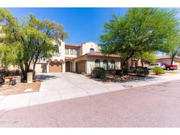 Inviting two-story home featuring a well-maintained yard and a spacious two-car garage, set under a clear, blue sky at 7925 S 52Nd Dr, Laveen, AZ 85339