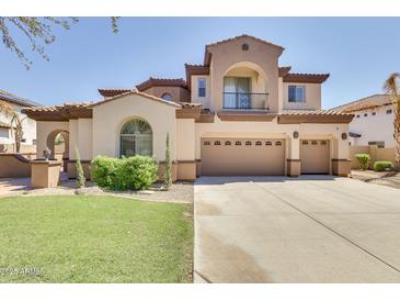 Stunning two-story home with a three-car garage, manicured lawn and a charming balcony with wrought iron details at 795 W Verbena Ln, Litchfield Park, AZ 85340