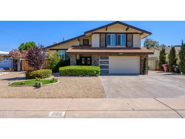 Beautiful two-story home featuring manicured landscaping and an attached garage at 8419 E Stella Ln, Scottsdale, AZ 85250