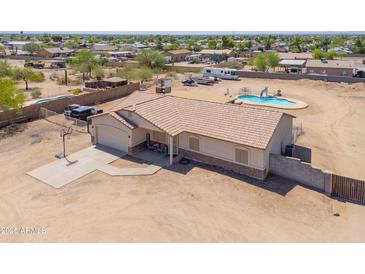 Charming single-Gathering home featuring a pool, spacious driveway with basketball hoop, and well-maintained landscaping at 9713 E El Paso St, Mesa, AZ 85207