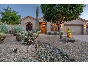Charming home with desert landscaping featuring cacti, stones, and mature trees at 9847 E Preserve Way, Scottsdale, AZ 85262