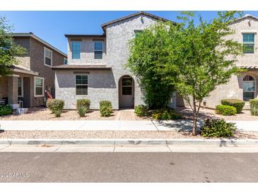Charming two-story home featuring a textured facade, arched entryway, and well-maintained desert landscaping at 302 N 69Th Pl, Mesa, AZ 85207