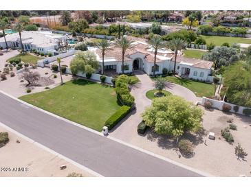 Elegant home with palm trees, green lawn and circular driveway at 6443 E Malcomb Dr, Paradise Valley, AZ 85253