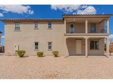 Charming two-story home with a balcony and low-maintenance landscaping at 820 E Agua Fria Ln, Avondale, AZ 85323