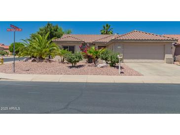 Charming single-story home with a well-maintained front yard and a two-car garage in a sunny neighborhood at 16536 W Rock Springs Ln, Surprise, AZ 85374