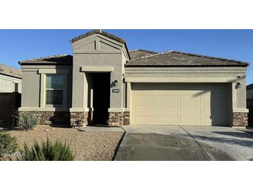 Charming single-story home with a two-car garage and well-maintained front yard at 30935 W Mulberry Dr, Buckeye, AZ 85396