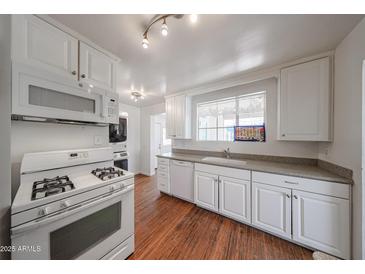 Bright kitchen features white cabinets, laminate countertops, and modern appliances at 3317 N 10Th Ave, Phoenix, AZ 85013