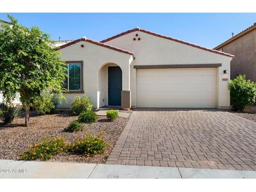 Charming single-story home with a paver driveway, desert landscaping, and a two car garage at 5429 W Chuck Box Rd, Laveen, AZ 85339