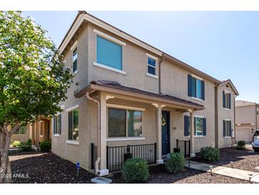 Charming tan two-story home featuring a quaint front porch and well-maintained landscaping at 2543 N 73Rd Dr, Phoenix, AZ 85035