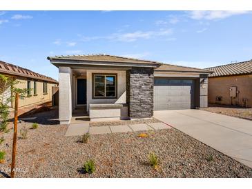 Charming single-story home featuring stone accents, a well-maintained yard and a two-car garage at 37549 W San Clemente St, Maricopa, AZ 85138