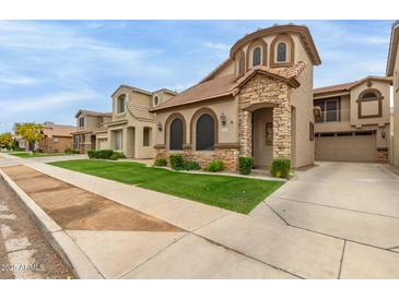 Charming home featuring a well-manicured lawn, stone accents, and a welcoming entrance at 5253 E Hilton Ave, Mesa, AZ 85206