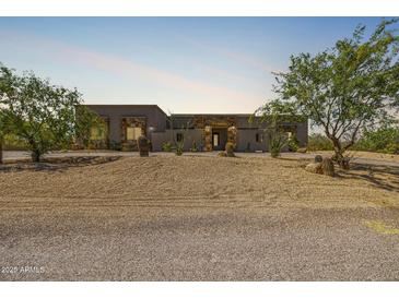 Stunning desert home featuring a landscaped front yard with native trees and stonework accents on the facade at 5515 E Dale Ln, Cave Creek, AZ 85331
