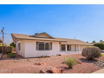 Charming single-story home featuring well-maintained landscaping and a classic design under a clear blue sky at 5633 E Colby St, Mesa, AZ 85205