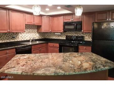 Modern kitchen boasts stainless steel appliances, stone countertops, and ample cabinet space at 7970 E Camelback Rd # 209, Scottsdale, AZ 85251