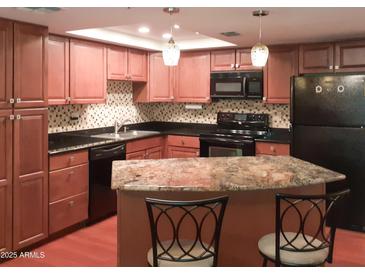 Charming kitchen with stainless steel appliances, granite countertops, and decorative lighting fixtures at 7970 E Camelback Rd # 209, Scottsdale, AZ 85251