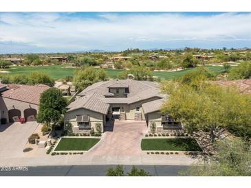 Stunning aerial view of a custom home on a golf course lot with beautiful desert landscaping at 8240 E Wingspan Way, Scottsdale, AZ 85255
