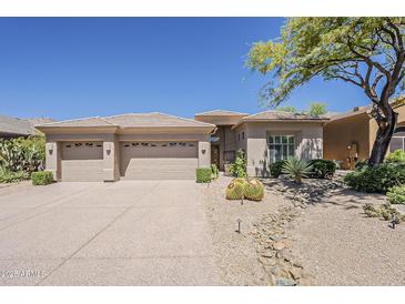Charming desert home featuring a three-car garage and drought-resistant landscaping at 9562 E Cavalry Dr, Scottsdale, AZ 85262