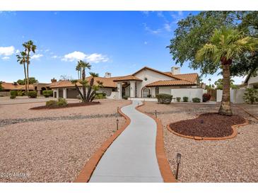 Stunning home featuring a tile roof, desert landscaping, and a long concrete walkway to the front entrance at 13631 N 70Th Dr, Peoria, AZ 85381